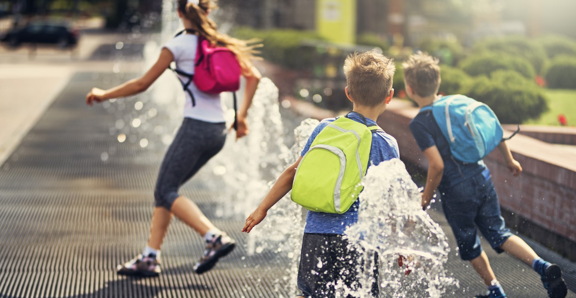 Kinderen spelend bij fontein in de stad.