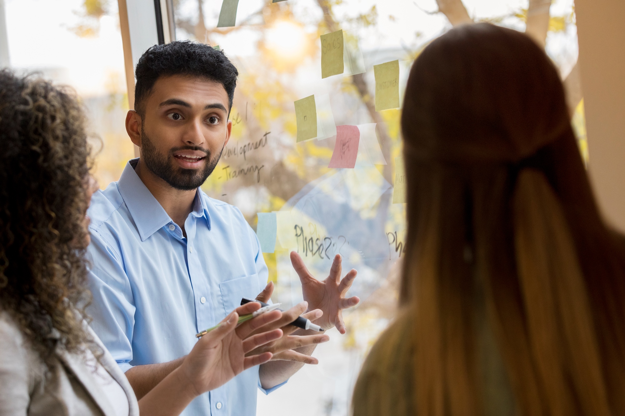 Collega bevlogen enthousiast in gesprek met collega's. Arcadis ziet voedselindustrie als spil in klimaatverandering