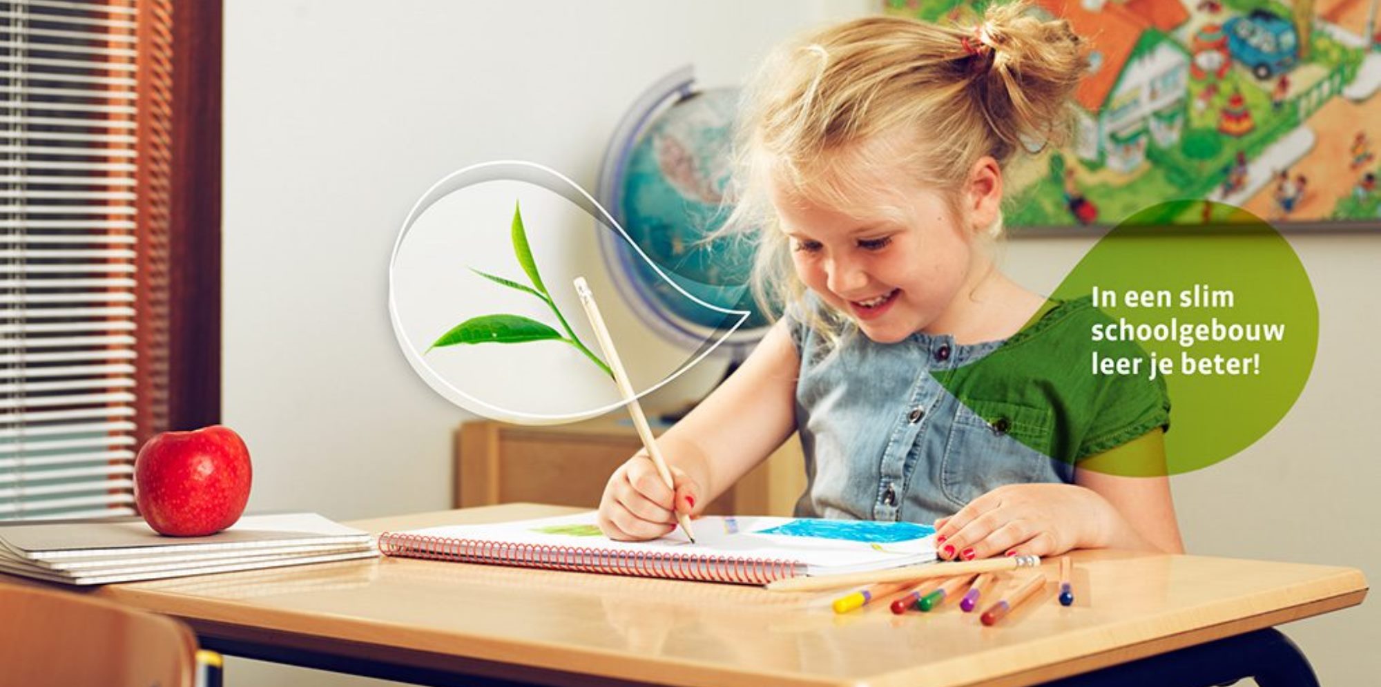 Blij kind op school werkend aan een tafeltje.